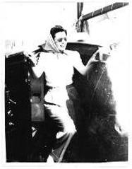 Black and white full-length portrait of Eva Duarte stepping out of a ship cabin