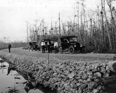 Black and white photo of cars parked along the Tamiami Trail in 1927