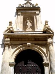 Facade of Iglesia de Santiago in Granada under a clear blue sky