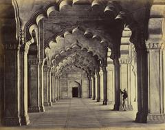 Interior of Moti Masjid Pearl Mosque in Agra showing ornate scalloped arches and central aisle with a man in traditional turban