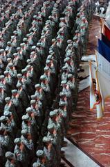US Soldiers, Sailors, Airmen, and Marines saluting the American flag during a large re-enlistment ceremony
