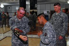 Retired Staff Sgt. Bradley K. Gruetzner explaining his prosthetic arm to service members at Al-Faw Palace, Camp Victory in Baghdad