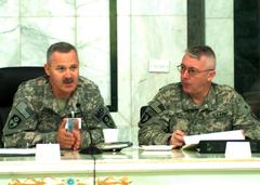 Brig. Gen. Donald Currier and Brig. Gen. Michael Smith discussing mission responsibilities at Police Transition Team Symposium