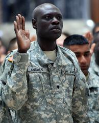 Spc. Mubarak Angalo raising right hand during American citizenship oath at Camp Victory naturalization ceremony