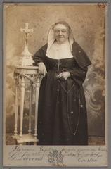 Florence Gezelle standing with rosary near table with crucifix