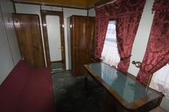 Interior of a vintage train carriage with wooden benches and historical design features