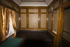 Interior of a historical train carriage with wooden benches and vintage design