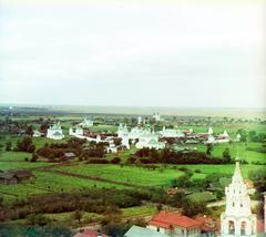 Pokrovsky Monastery in Suzdal with golden domes and brick walls under a blue sky
