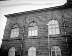 Exterior shot of the east upper floor of Althingi building with broken windows after 1949 riots