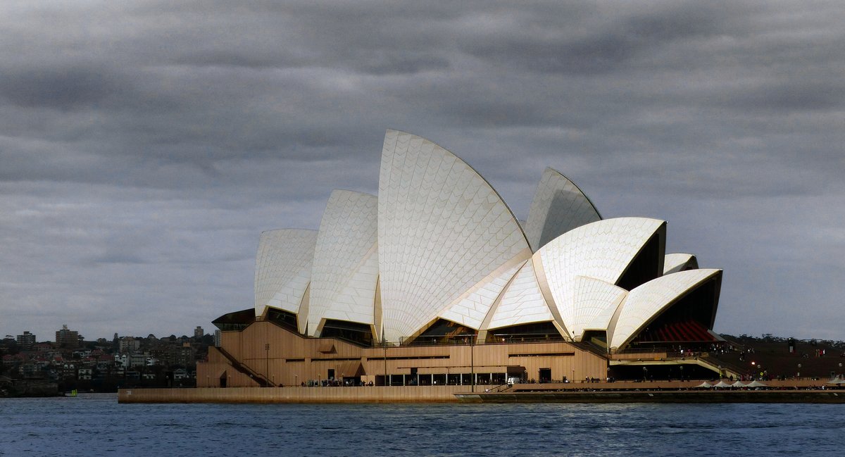 Sydney Opera House with scenic waterfront and blue sky