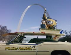 Green Bay Packer flag mounted on a vehicle driving past the Gateway Arch in St. Louis