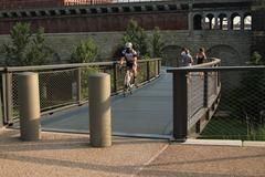Cyclist wearing a mask rides on the bridge at St. Louis Arch grounds