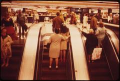 Black and white image of arrivals and departures at an underground station with escalators