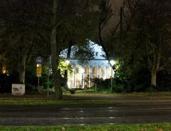 Konzerthaus Karlsruhe at night illuminated over tram tracks in Hermann-Billing-Straße