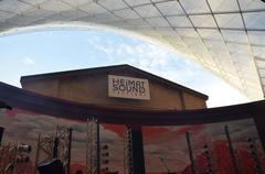 Crowded outdoor music festival market stalls and tents under sunny sky
