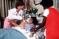 Pediatric nurse adjusting leg cast with skeletal traction on a young patient at Wilford Hall Medical Center