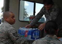 Master Sgt. Patricia Rodgers passing a case of water to Staff Sgt. Richard Rijos at Wilford Hall Medical Center Deployment dock