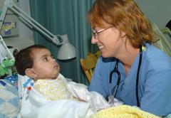 Air Force pediatrician examining a baby recovering from IED blast