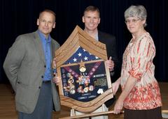 U.S. Air Force Col. James McClain and U.S. Army Col. Mary McAfee presenting a shadow box to Command Chief Master Sgt. Richard Robinson at his retirement dinner