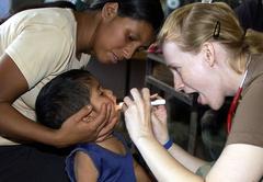 Air Force Capt. Carrie Schmid examining the mouth of a Honduran child during medical training