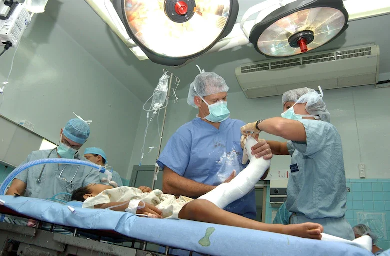 Lt. Col. Eric Ritchie and Staff Sgt. Jolie Zygulski applying a cast to a patient's leg at Hospital Esquela in Tegucigalpa, Honduras