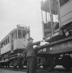 Black and white photo of uniformed tram conductors standing beside a tram wagon from Bremen in Amsterdam, May 31, 1946