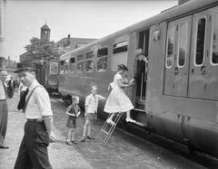 Black and white photo of students using Haarlemmermeerstation in Amsterdam on July 6, 1957