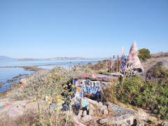 Panoramic view of Albany Bulb with people walking and lookout structures under clear blue sky
