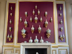Various porcelain items including plates, cups, and bowls arranged on shelves