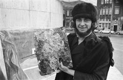 American artist George Yalick painting at National Monument on the Dam, Amsterdam, 1970