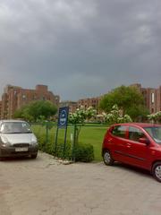 Amity University NOIDA Campus under stormy sky with dark clouds and rain