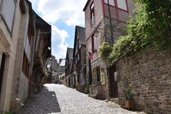 Street view of La Rue Jerzual in Dinan with old stone buildings and a cobblestone path