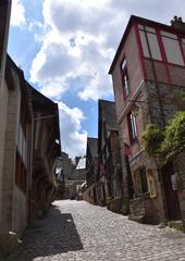 View of La Rue Jerzual street in Dinan with charming old buildings and vibrant greenery