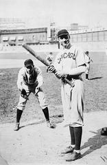 Major league baseball players Jack Pfiester crouching and Solly Hofman batting during a Chicago Cubs game at Baker Bowl in Philadelphia