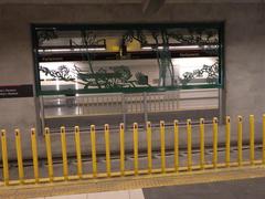 Interior of Parliament Station in Ottawa featuring vibrant artwork and a train coupling barrier