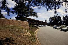 Cars parked outside Mission 66 Visitor Center surrounded by trees and mountains in Rocky Mountain National Park