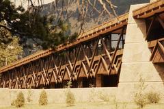 Mission 66 visitor center surrounded by plants and trees in Rocky Mountain National Park with mountains in the background and a flag pole