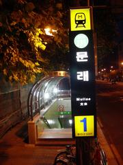 Mullae Station Exit 1 illuminated at night with building lights in the background