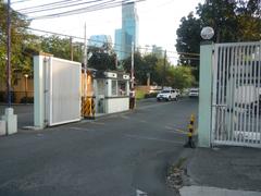 View of Jupiter Street in Bel-Air Village, Makati City with commercial buildings including Papa John's Pizza and Burger King on a sunny day