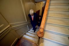 U.S. Secretary of State John Kerry climbing stairs at Benjamin Franklin House in London with Dr. Marcia Balisciano