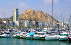 Marina in Alicante with boats docked and cityscape in the background