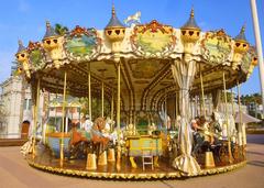 Carousel at Alicante harbor during daytime with people enjoying the ride