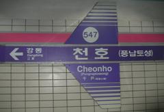 Seoul Subway Cheonho Station entrance with blue signage and commuters