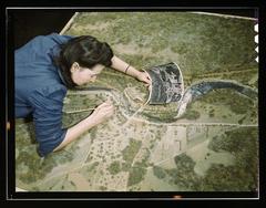 Woman correcting camouflage on model defense plant in camouflage class at New York University