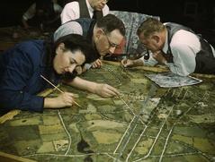 Men and women in a camouflage class at New York University preparing models from aerial photographs for military and industrial jobs