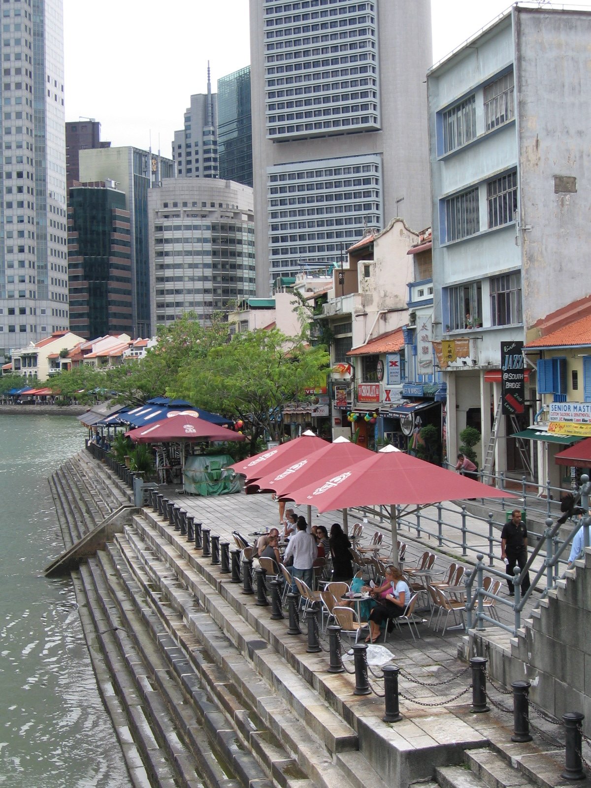 Evening view of Boat Quay waterfront with historical buildings and boats in Singapore