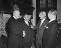 Black and white photo of the 75th anniversary celebration of the Amstelkring in Amsterdam with Deken van Amsterdam mgr. G. P. J. van der Berg and Wethouder mr. A. de Roos