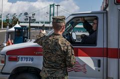 U.S. Marine Corps Lance Corporal guiding ambulance to hospital ship USNS Mercy during COVID-19 response
