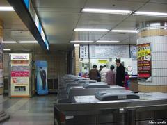 Hyehwa Station entrance with pedestrians and vehicles on a sunny day