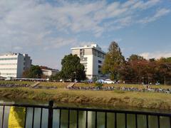 Bunkyo University Koshigaya Campus viewed across Motoarakawa River with blurred sign on the left-bottom